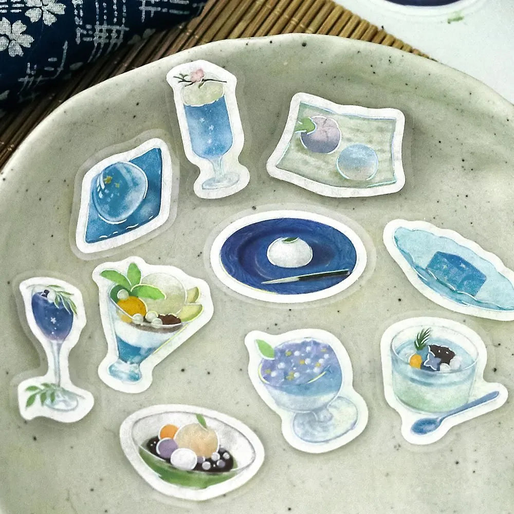 Sheet of blue-themed café flake stickers showing petite plates, parfaits, jelly desserts and drinks with shimmering foil highlights.