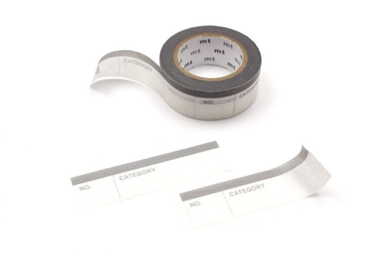 mt Perforated Label Tape — Number & Category — rolled out on paper